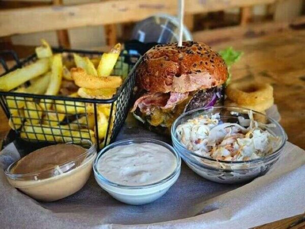 Poctivý hovädzí burger s poriadnou porciou príloh – hranolčeky, coleslaw šalát aj cibuľové krúžky